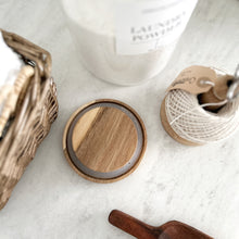 Load image into Gallery viewer, Wooden lid on a white surface with a candle and basket in the background