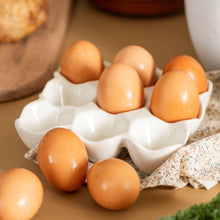 Load image into Gallery viewer, White ceramic egg tray with brown eggs on a wooden surface with bread and greens.
