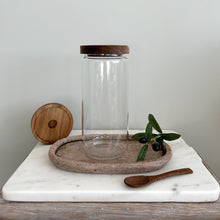 Load image into Gallery viewer, Glass pantry jar with wooden acacia lid on a marble surface with olive branch and leaves.