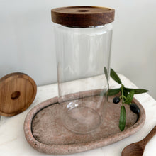 Load image into Gallery viewer, Clear glass jar with wooden lid on a stone tray with a white background
