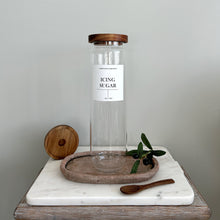 Load image into Gallery viewer, Clear glass pantry jar with acacia lid and white label on a marble surface with a wooden spoon and tray.
